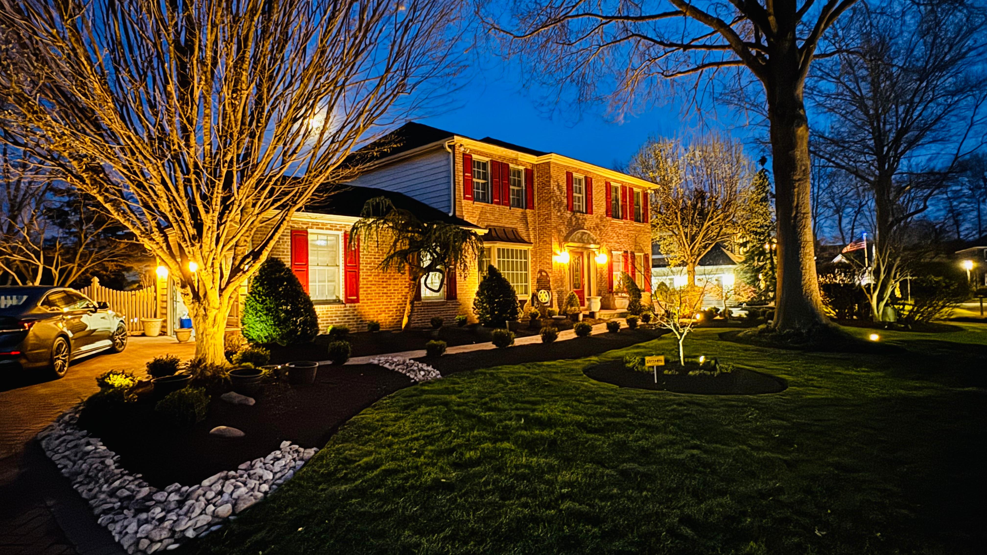 JIREH SERVICE landscaping project illuminated at dusk